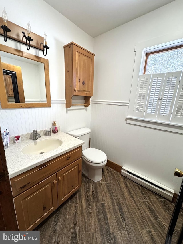 bathroom featuring vanity, a baseboard heating unit, wood-type flooring, and toilet