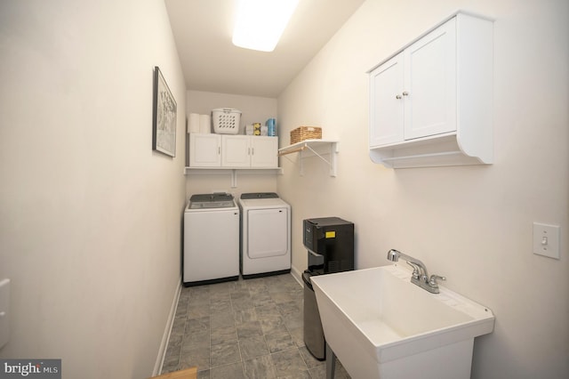 laundry area with independent washer and dryer, a sink, cabinet space, and baseboards