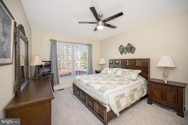 bedroom with light colored carpet, ceiling fan, visible vents, and baseboards