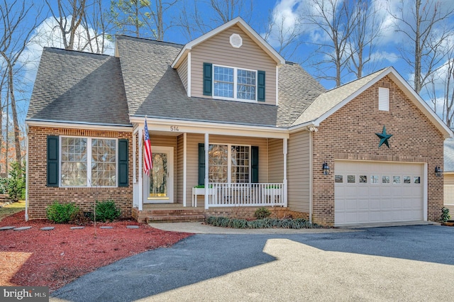 view of front of home featuring a garage, driveway, a porch, and brick siding