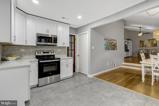 kitchen with light countertops, visible vents, decorative backsplash, appliances with stainless steel finishes, and white cabinets