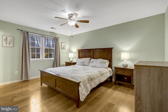 bedroom featuring ceiling fan, light wood-type flooring, visible vents, and baseboards