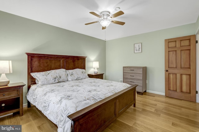 bedroom featuring light wood-type flooring, a ceiling fan, and baseboards