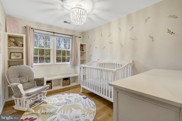 bedroom featuring a notable chandelier and wood finished floors