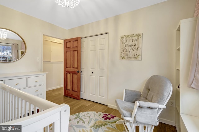 bedroom featuring a chandelier, a closet, baseboards, and light wood finished floors