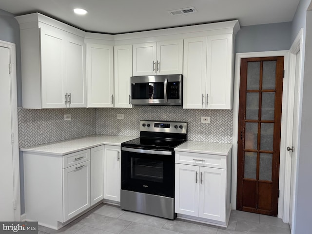 kitchen featuring light countertops, appliances with stainless steel finishes, backsplash, and visible vents