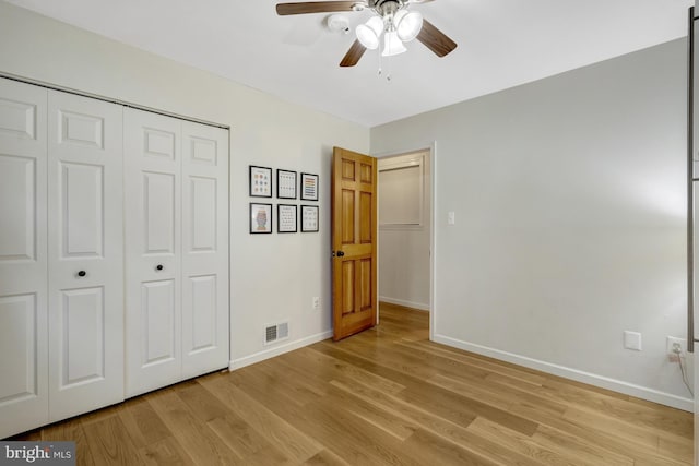 unfurnished bedroom featuring a closet, visible vents, ceiling fan, light wood-type flooring, and baseboards