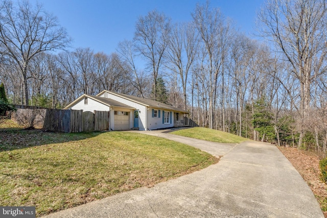 view of property exterior with a garage, concrete driveway, a lawn, and fence