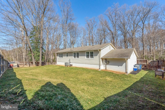 back of property featuring a fenced backyard, a lawn, and brick siding