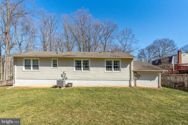 back of house featuring a lawn, cooling unit, and fence