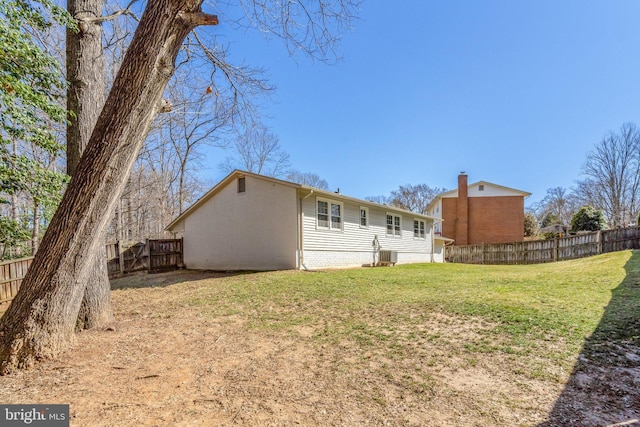 rear view of property with fence and a lawn