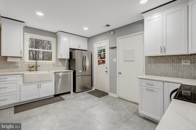 kitchen featuring visible vents, appliances with stainless steel finishes, white cabinetry, a sink, and recessed lighting