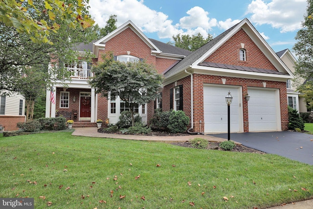 view of front facade with a garage, a balcony, and a front yard