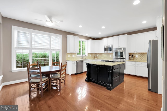 kitchen with appliances with stainless steel finishes, a center island, sink, and white cabinets