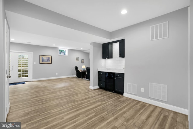 bar featuring backsplash and light hardwood / wood-style flooring