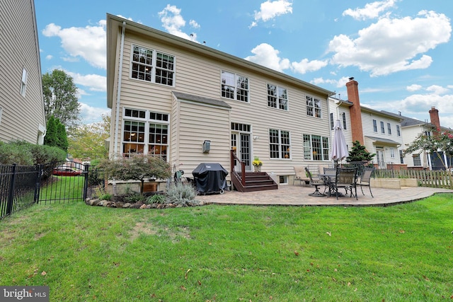 back of property with a yard and a patio