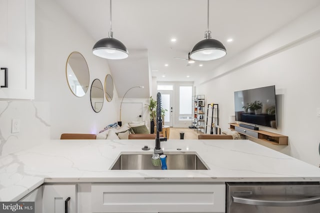 kitchen with dishwasher, sink, pendant lighting, and white cabinets