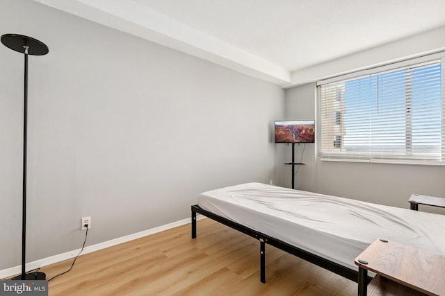 bedroom featuring baseboards and wood finished floors