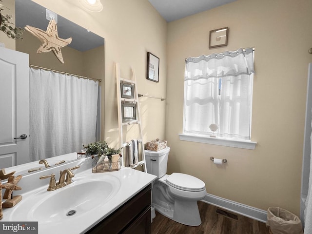 bathroom with wood-type flooring, vanity, and toilet