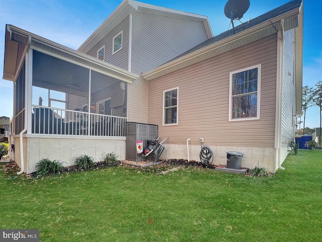 rear view of property featuring a yard, a sunroom, and ceiling fan