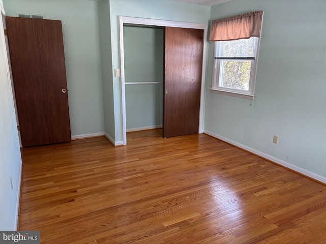 unfurnished bedroom featuring light wood-type flooring and a closet