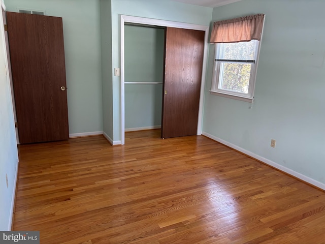 unfurnished bedroom with light hardwood / wood-style floors and a closet