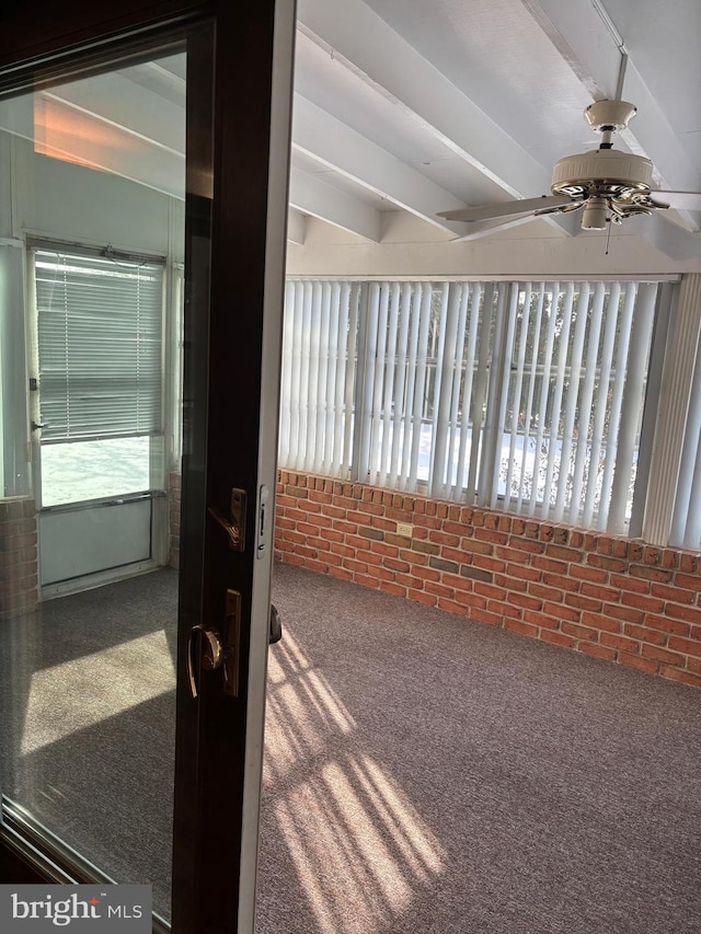 unfurnished sunroom featuring ceiling fan and beam ceiling