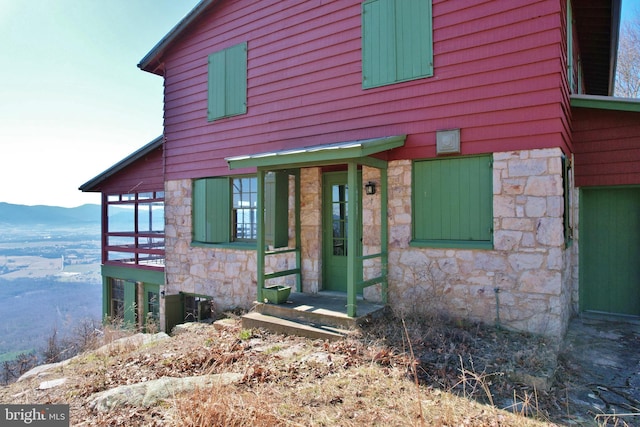 exterior space featuring a mountain view and stone siding