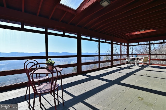 unfurnished sunroom with a mountain view and a skylight