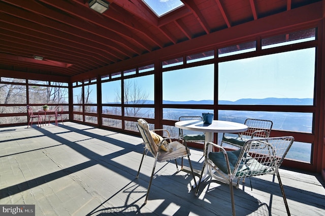 unfurnished sunroom with a mountain view and a skylight