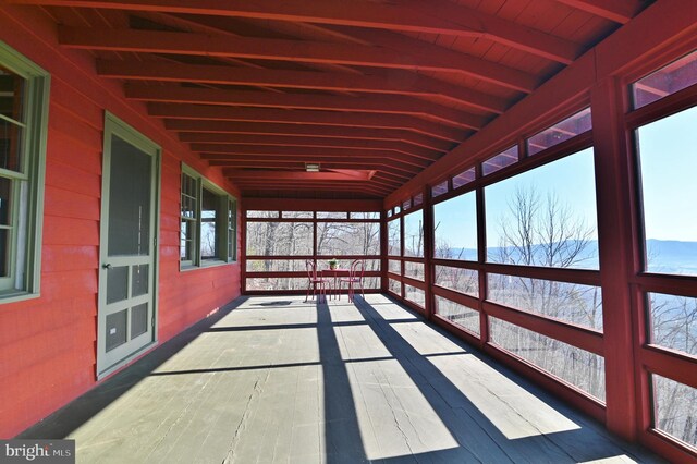 unfurnished sunroom with beam ceiling