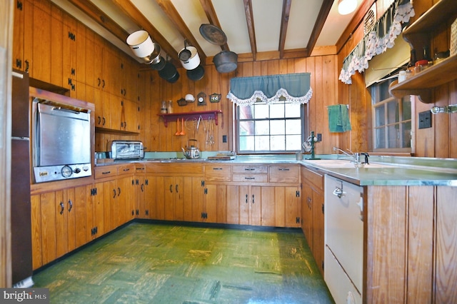 kitchen featuring beamed ceiling, open shelves, a sink, wood walls, and dark floors