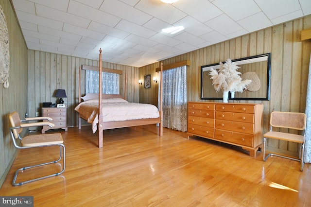 bedroom with wood walls and wood finished floors