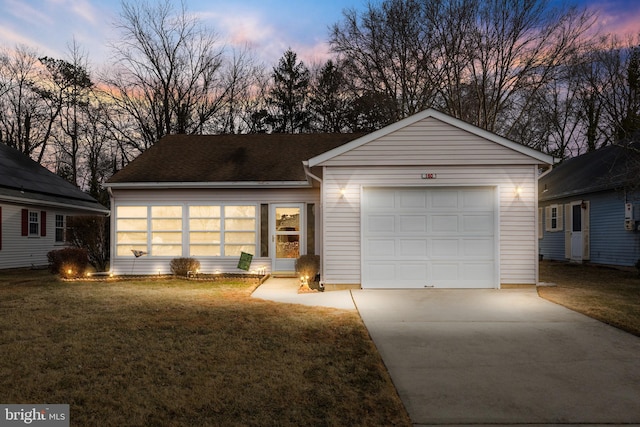 ranch-style home featuring a garage, a yard, roof with shingles, and concrete driveway