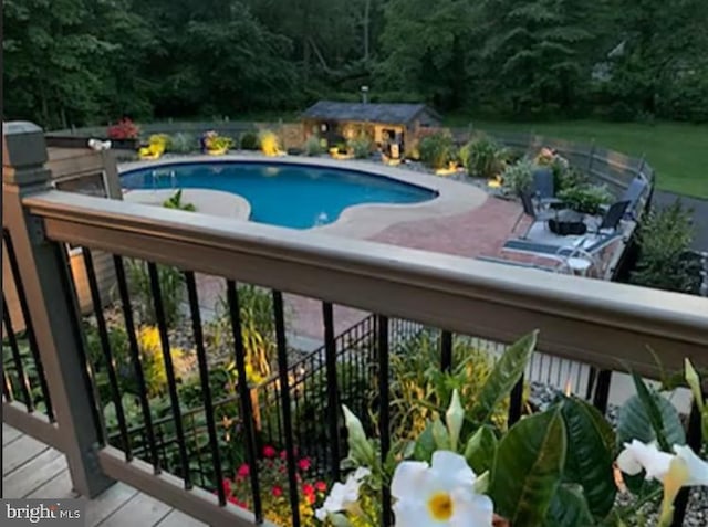 view of pool with a wooden deck and an outdoor structure