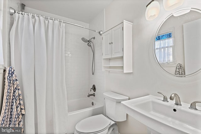 bathroom with toilet, shower / bathtub combination with curtain, and a sink