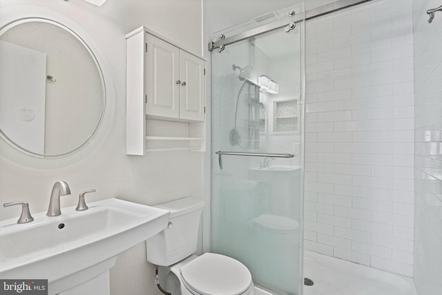 full bath with a sink, a shower stall, and toilet