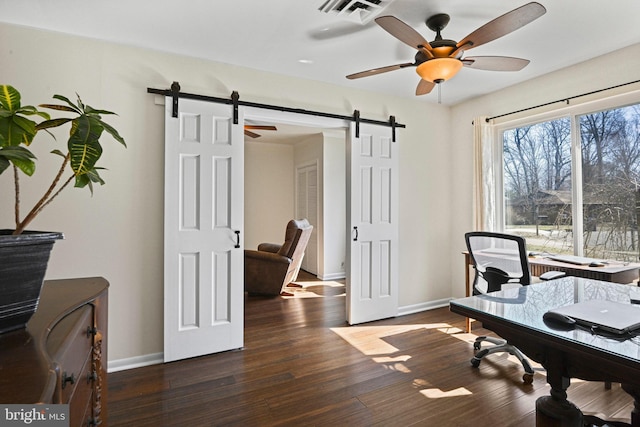 office featuring wood finished floors, visible vents, ceiling fan, and a barn door