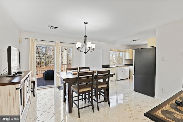 dining space featuring visible vents, a chandelier, and light tile patterned flooring