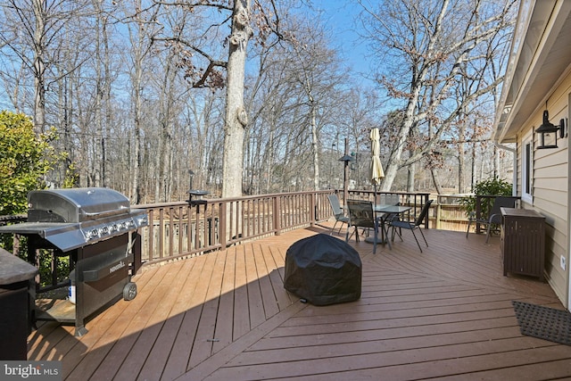 wooden deck featuring outdoor dining space and grilling area