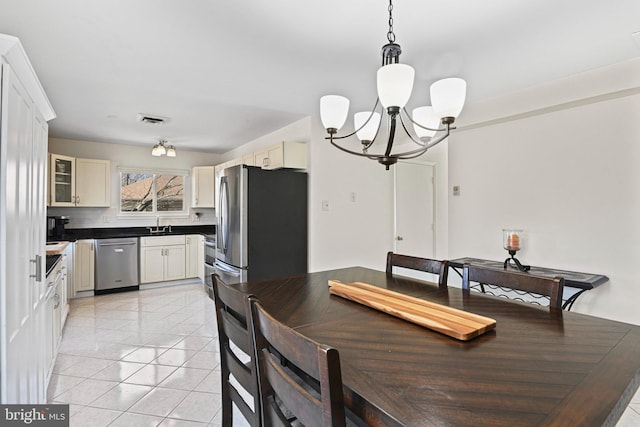 dining room featuring light tile patterned floors, visible vents, and a notable chandelier