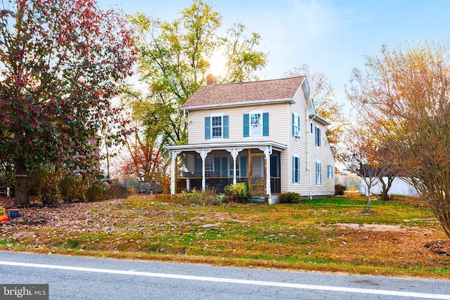 view of front of house featuring a sunroom, roof with shingles, and a chimney