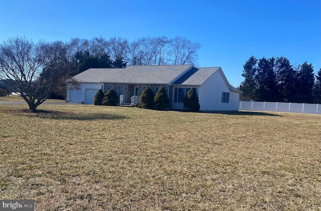 ranch-style house featuring a garage, fence, and a front lawn