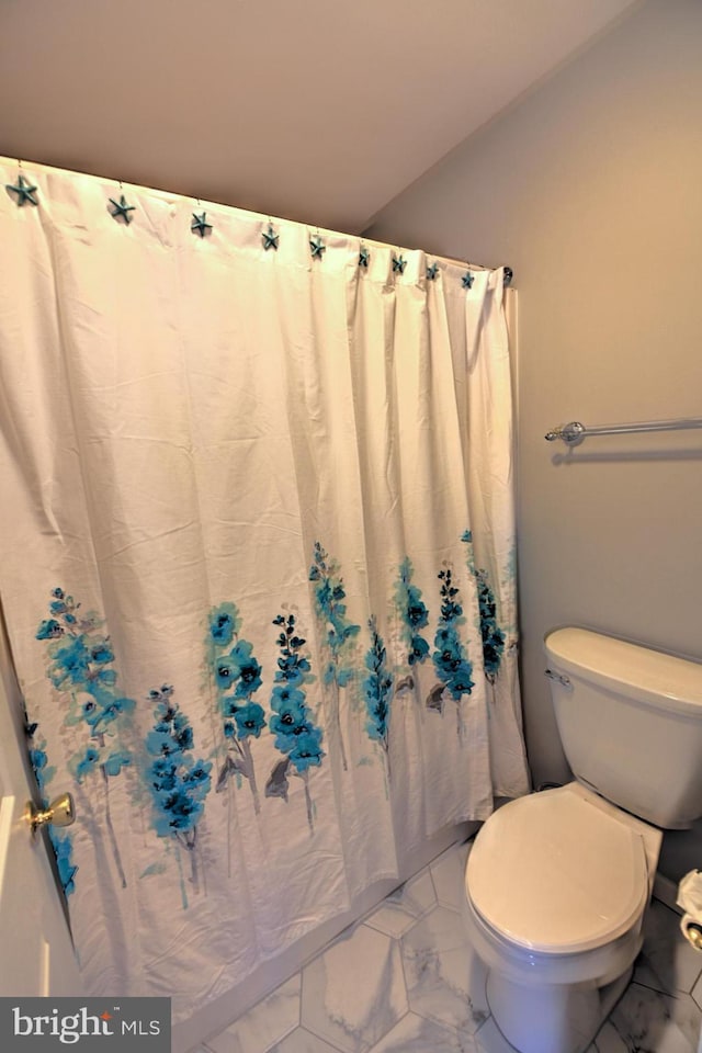 full bathroom featuring marble finish floor, toilet, and a shower with curtain