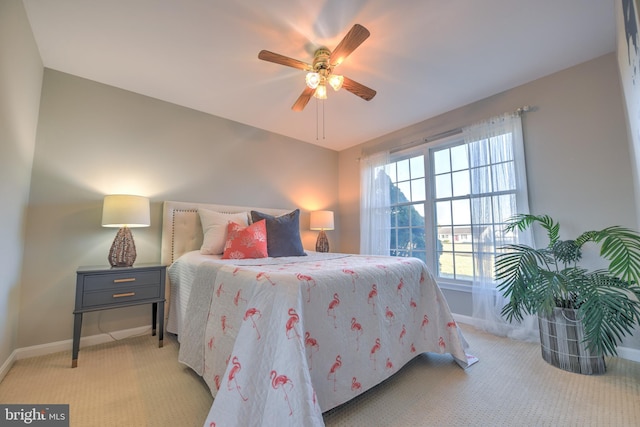 bedroom featuring light colored carpet, ceiling fan, and baseboards