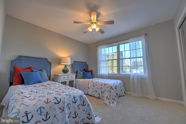 carpeted bedroom with ceiling fan and baseboards