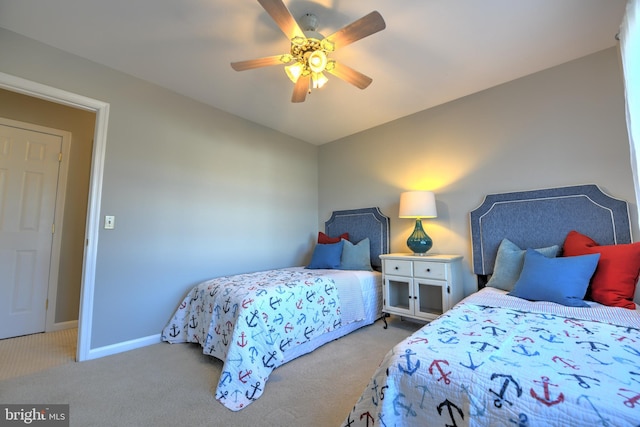 carpeted bedroom with ceiling fan and baseboards