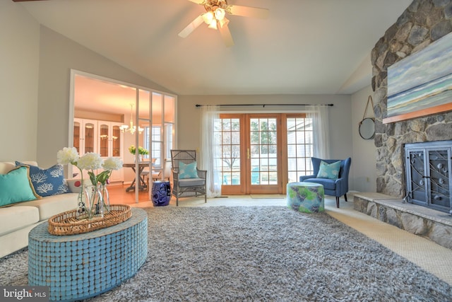 carpeted living room featuring lofted ceiling and ceiling fan with notable chandelier