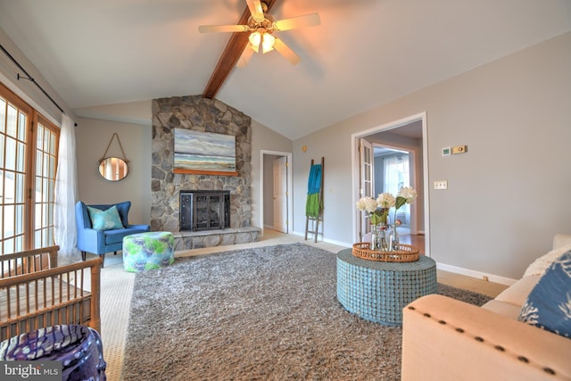 living room featuring vaulted ceiling with beams, ceiling fan, carpet floors, a fireplace, and baseboards