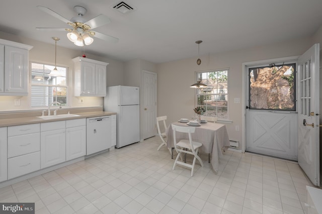 kitchen featuring sink, white appliances, hanging light fixtures, white cabinets, and a baseboard radiator